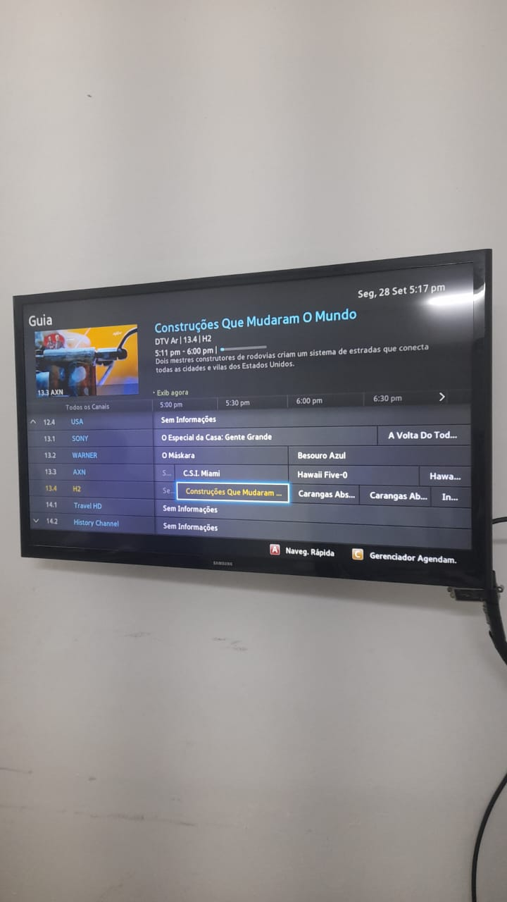 Televisor exibindo a grade completa de programação